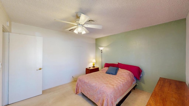 carpeted bedroom featuring ceiling fan and a textured ceiling