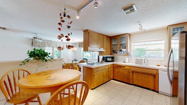 kitchen featuring white appliances, plenty of natural light, kitchen peninsula, and sink