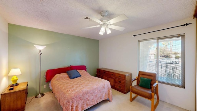 bedroom featuring ceiling fan, light carpet, and a textured ceiling