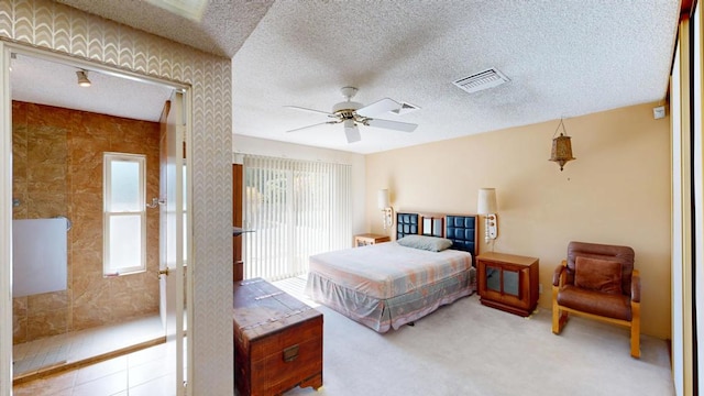 bedroom featuring ceiling fan, light colored carpet, and a textured ceiling