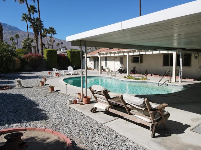 view of swimming pool with a patio and a mountain view