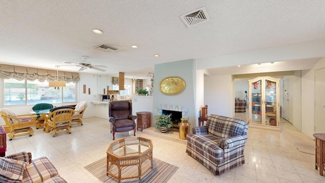 living room featuring a textured ceiling and ceiling fan