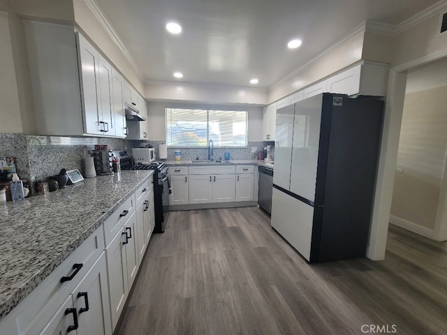 kitchen featuring stainless steel appliances, ornamental molding, white cabinets, and light stone counters