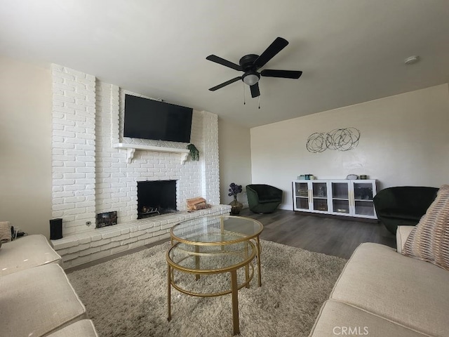 living room featuring dark hardwood / wood-style flooring, ceiling fan, and a fireplace