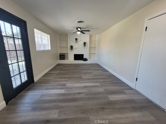 unfurnished living room with hardwood / wood-style flooring, a fireplace, built in features, and ceiling fan