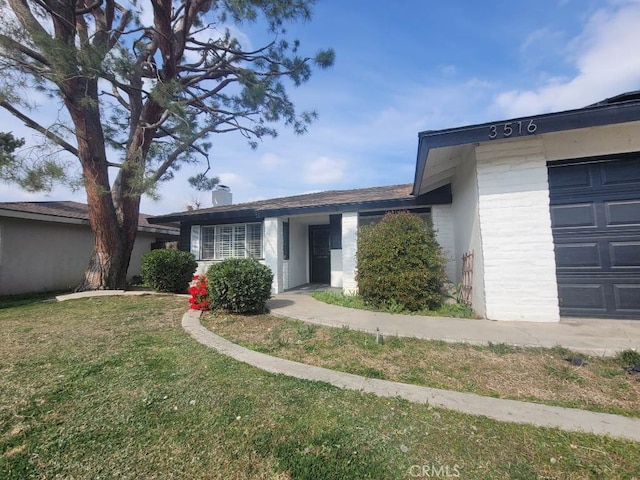 view of front of property featuring a garage and a front yard