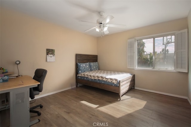 bedroom with dark hardwood / wood-style flooring and ceiling fan