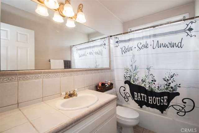 full bathroom with tile walls, a chandelier, vanity, toilet, and shower / bath combo with shower curtain