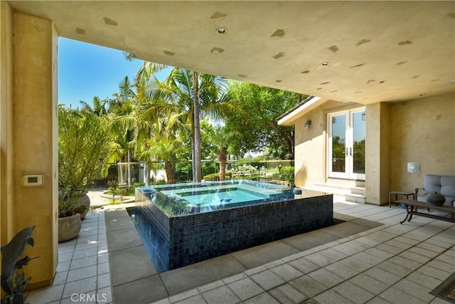 view of swimming pool with an in ground hot tub, a patio, and french doors