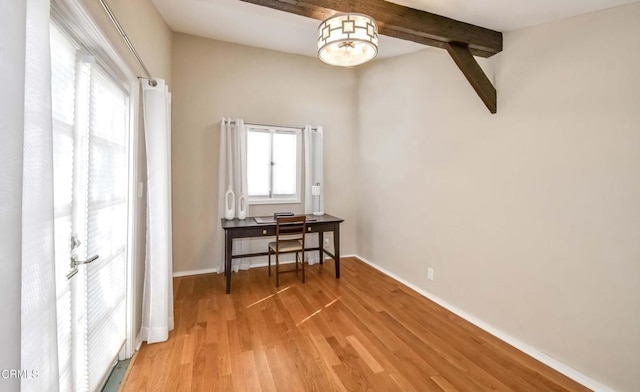 interior space with lofted ceiling with beams, baseboards, and wood finished floors