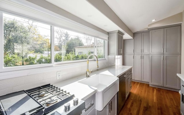 kitchen with tasteful backsplash, gray cabinets, light countertops, and a sink