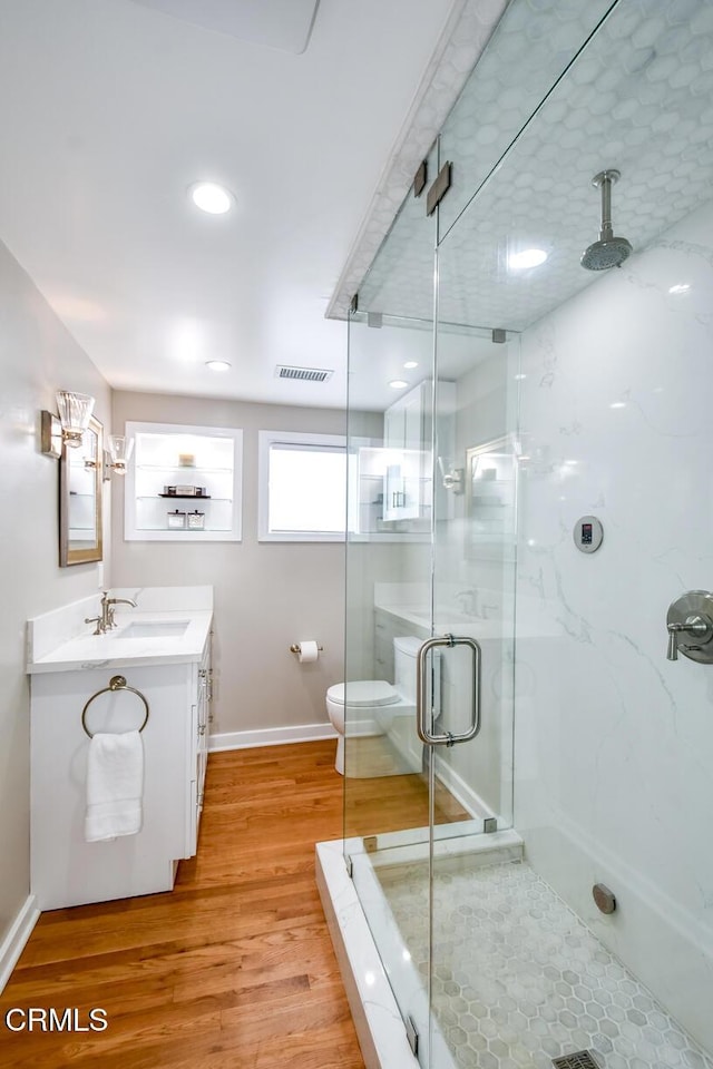 full bathroom featuring visible vents, toilet, a stall shower, vanity, and wood finished floors