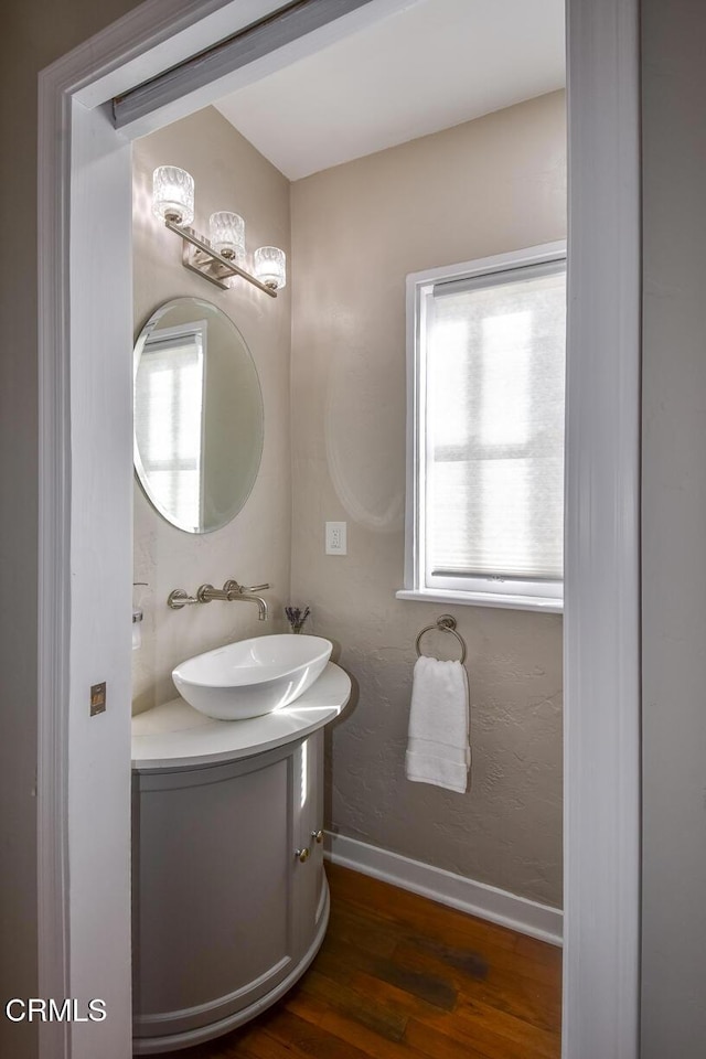 bathroom featuring wood finished floors, vanity, and baseboards