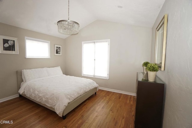 bedroom with lofted ceiling, baseboards, and wood finished floors