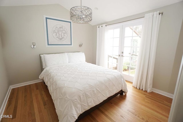 bedroom featuring vaulted ceiling, wood finished floors, and baseboards