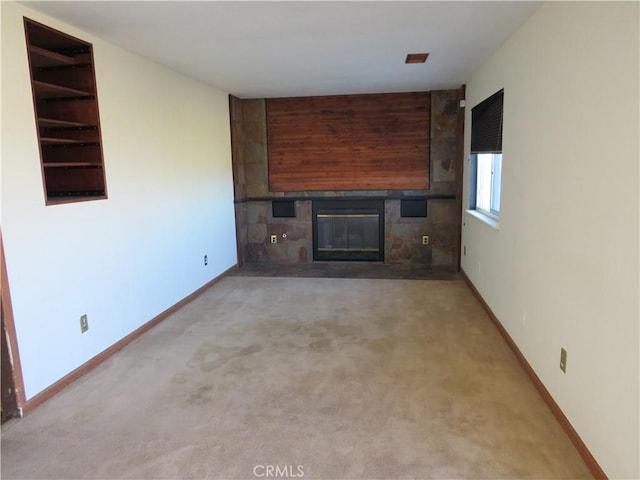 unfurnished living room featuring light colored carpet and a large fireplace