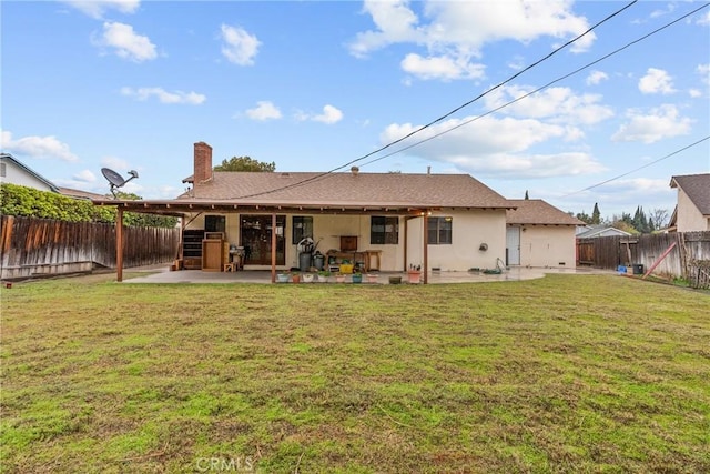 rear view of property with a yard and a patio area