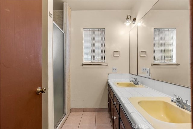 bathroom with an enclosed shower, vanity, a wealth of natural light, and tile patterned floors