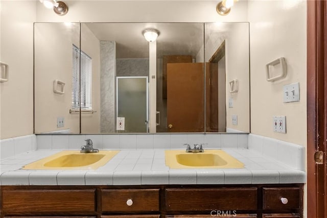 bathroom with vanity and a shower with door