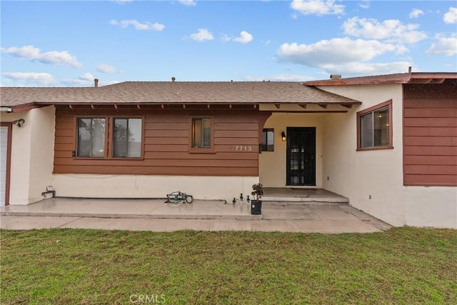 rear view of house with a yard and a patio area