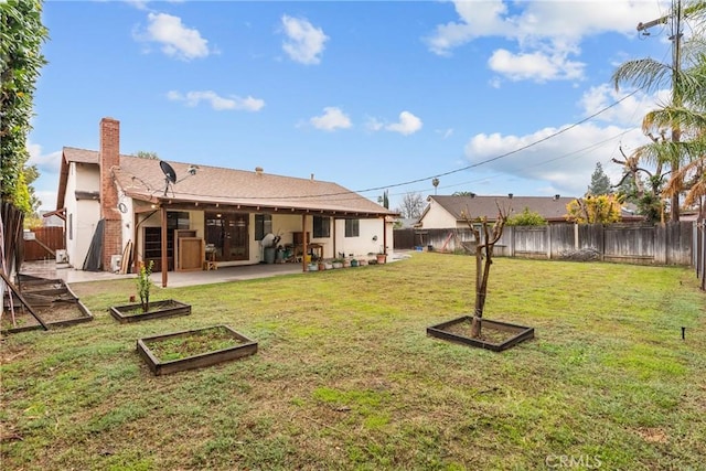 back of property with a yard and a patio area