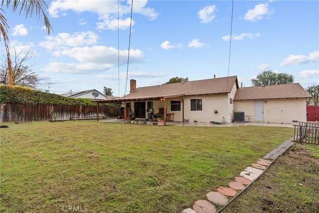 back of property with a yard, central AC, and a patio area