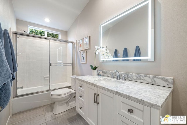 full bathroom with vanity, toilet, and combined bath / shower with glass door