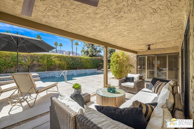 view of patio / terrace featuring an outdoor living space, pool water feature, a fenced in pool, and ceiling fan