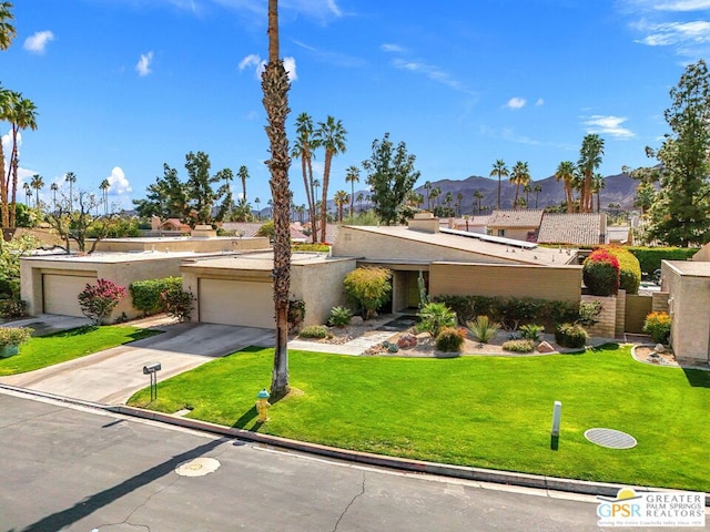 view of front of home with a mountain view, a garage, and a front yard