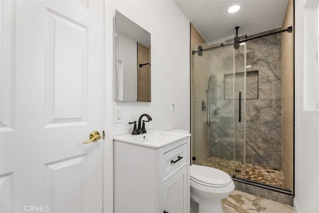 bathroom featuring vanity, toilet, and walk in shower