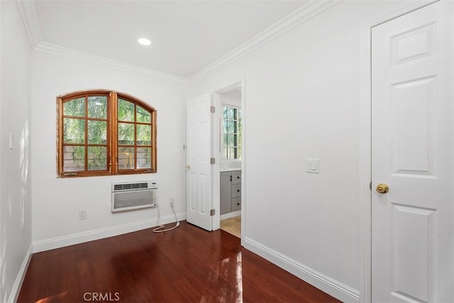 unfurnished bedroom with ornamental molding, a wall mounted air conditioner, and dark hardwood / wood-style flooring