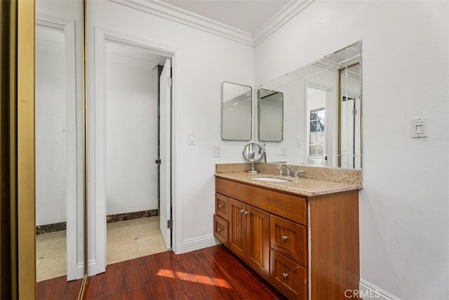 bathroom featuring crown molding, hardwood / wood-style floors, and vanity