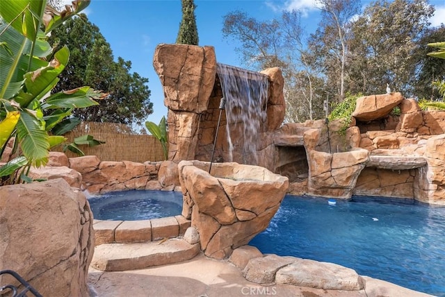 view of pool with pool water feature and an in ground hot tub