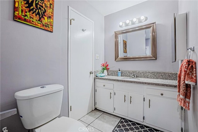 bathroom featuring toilet, vanity, and tile patterned flooring