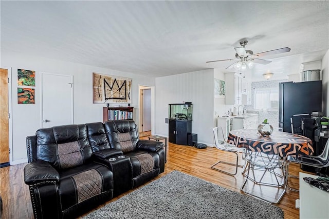 living room with ceiling fan, sink, and hardwood / wood-style floors