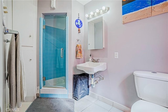 bathroom featuring tile patterned flooring, a shower with door, and toilet