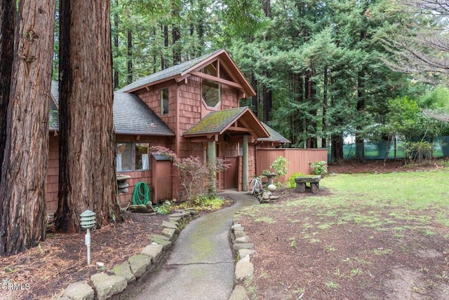 view of front of property with a shingled roof and fence