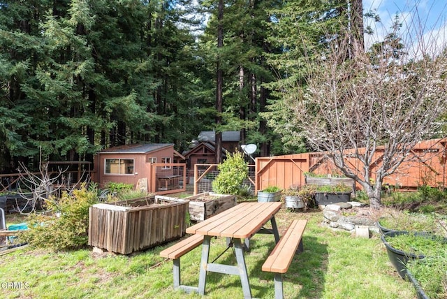 view of yard featuring an outbuilding, a garden, fence, and a shed