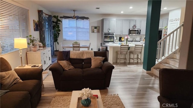 living room with ceiling fan and light hardwood / wood-style floors