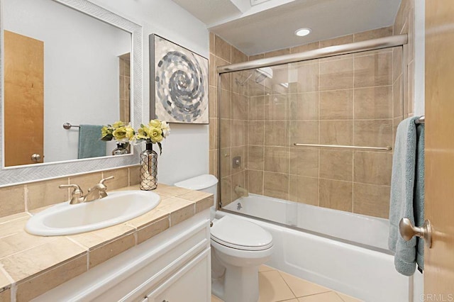 full bathroom with vanity, combined bath / shower with glass door, tile patterned floors, and toilet