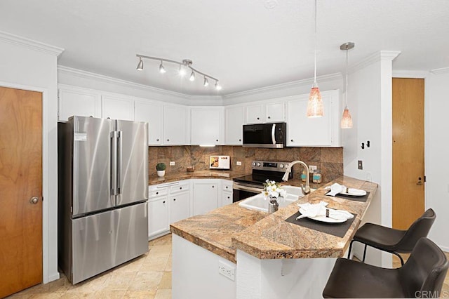 kitchen featuring pendant lighting, appliances with stainless steel finishes, white cabinetry, a kitchen breakfast bar, and kitchen peninsula