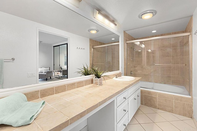 bathroom featuring vanity, combined bath / shower with glass door, and tile patterned floors