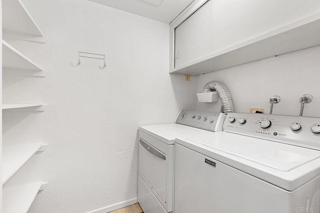 laundry room featuring cabinets and washer and clothes dryer