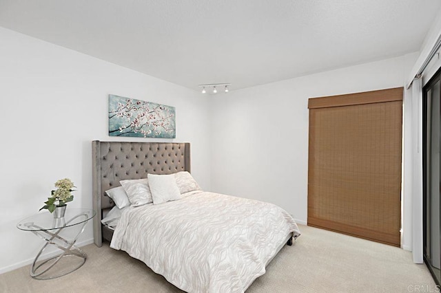 carpeted bedroom featuring rail lighting