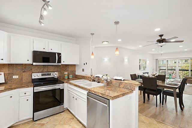 kitchen with sink, white cabinets, hanging light fixtures, kitchen peninsula, and stainless steel appliances