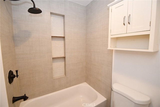 bathroom featuring tiled shower / bath combo and toilet