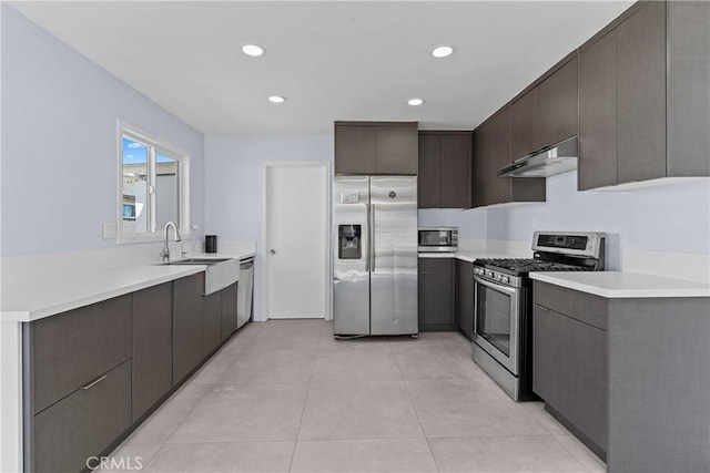 kitchen featuring stainless steel appliances, dark brown cabinetry, under cabinet range hood, and modern cabinets