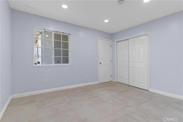 unfurnished bedroom with baseboards, a closet, and recessed lighting