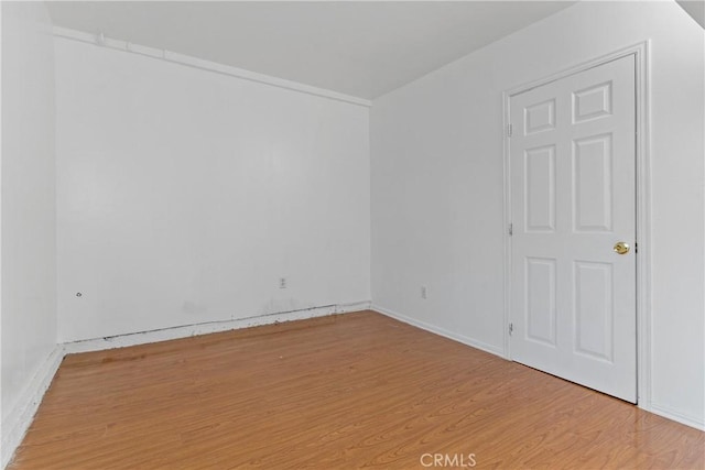 unfurnished room with wood finished floors and baseboards