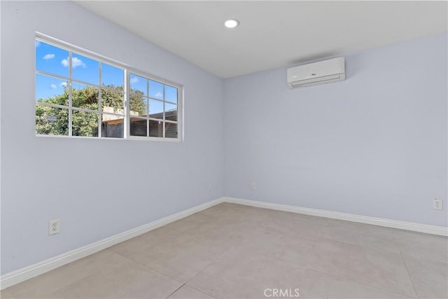 spare room featuring recessed lighting, a wall mounted air conditioner, and baseboards